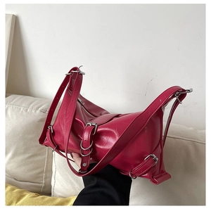 Gros plan sur le sac fuchsia en cuir verni plissé avec boucles métalliques argentées