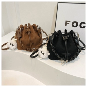 Detail of suede bucket bags with woven handles and cute plush monster charms on display