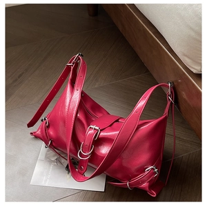 Détail du sac à bandoulière rose rouge avec texture plissée brillante et boucles argentées