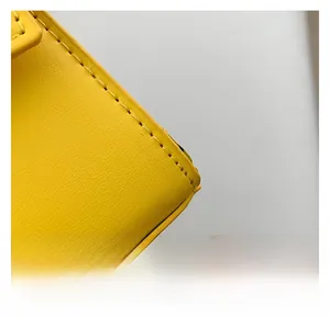 Dettaglio della trama in pelle giallo brillante con cuciture premium sulla borsa piccola