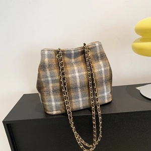 Classic plaid wool tote bag with golden metal chain strap on minimalist black table