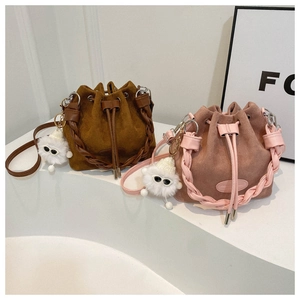 Detail of frosted bucket bags in caramel and pink with woven handles and plush charms