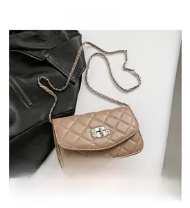 Close-up of quilted beige crossbody bag with silver crystal flower twist lock and chain strap