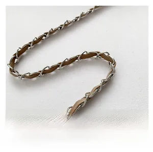 Close-up of silver chain shoulder strap with brown leather interlaced detail