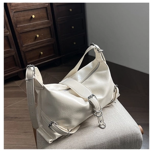 Détail du sac à bandoulière blanc crème avec cuir plissé et boucles métalliques argentées