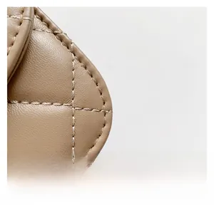Detailed close-up of beige quilted leather textures with precise white stitching work