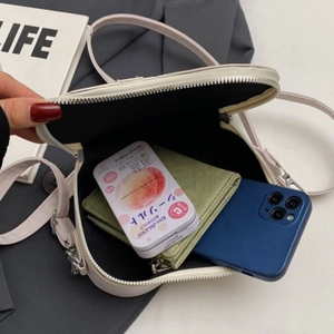 Creamy white crossbody bag showing interior capacity for smartphone and wallet