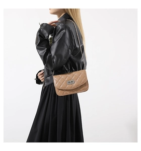 Quilted khaki chain bag with silver turn-lock shown on model in a side view