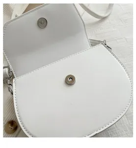 Détail du sac selle en cuir PU blanc avec fermoir magnétique argenté et coutures