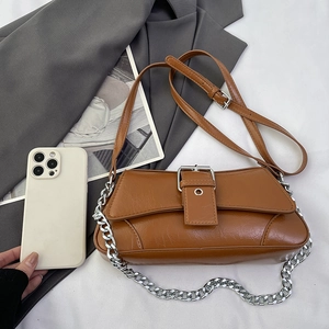 Retro brown baguette bag with silver chain and cracked texture leather on gray blazer