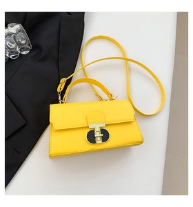 Detail of a bright yellow leather crossbody bag with a gold T-bar twist lock closure