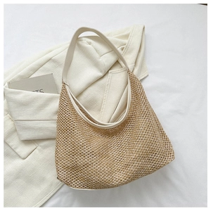 Detail shot of the woven mesh texture and leather strap on a beige hobo shoulder bag