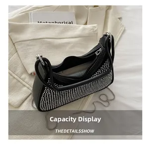 Internal view showing the large storage capacity of this studded black leather shoulder bag