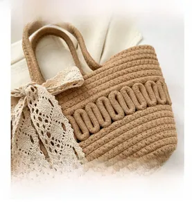 Detaillierte Nahaufnahme einer Strohhandtasche mit eleganter Schleife aus cremefarbener Spitze