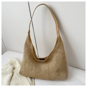 Detail of hollow woven straw bag featuring smooth leather shoulder strap and edges