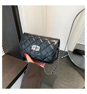 Close-up of black quilted crossbody bag with diamond-encrusted twist lock and chain strap