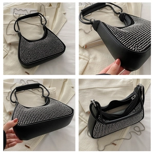 Detail view of black underarm bag with silver rhinestone studs and chain strap