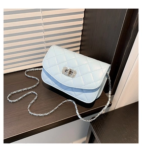 Detail of light blue quilted leather bag with diamond-encrusted twist lock and chain strap