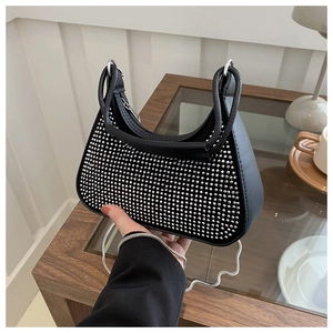 Détail d'un sac baguette noir chic orné de strass argentés brillants et d'une fine chaîne