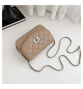 Detail of quilted beige crossbody bag with silver chain strap and diamond-encrusted lock