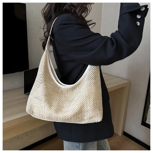 Detail of the woven mesh texture and cream-white shoulder strap on a large hobo bag