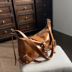 Sac bandoulière tendance en cuir verni marron caramel avec sangles réglables et détails argentés