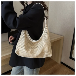 Close-up of beige woven hobo bag with white leather trim and textured straw mesh detail