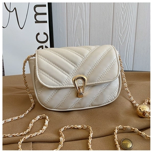 Detalle de bolso acolchado blanco con correa de cadena dorada y dije de bola ajustable