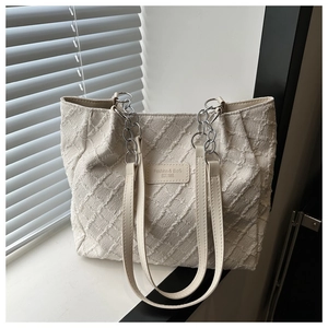 Détail du sac fourre-tout tissé crème avec motif 3D et étiquette en cuir