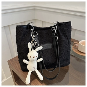 Détail du sac cabas noir en tissu plissé avec un porte-clés lapin blanc mignon