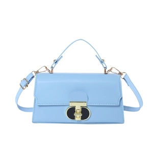 Minimalist sky blue flap square bag with gold circular lock and chain strap on white background
