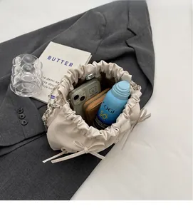 Top view of open beige pleated bucket bag showing large capacity for phone and cosmetics
