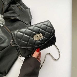Quilted black chain crossbody bag with sparkling rhinestone lock on white background