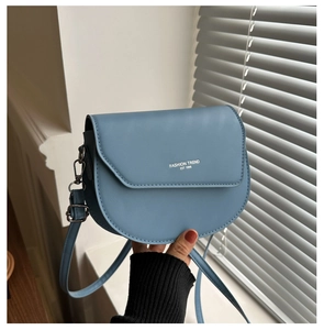 Vue détaillée du sac besace en cuir PU bleu mat avec typographie imprimée blanche