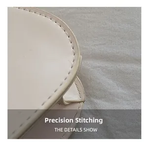Détail macro des coutures précises et du bord en cuir lisse d'un sac à bandoulière