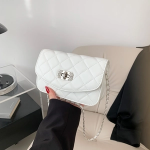 White quilted crossbody chain bag with rhinestone lock shown in a modern home setting