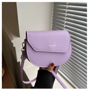 Détail du sac selle lavande montrant le cuir PU et l'imprimé texte mode tendance