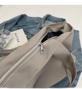 Detailed close-up of smooth silver metal zipper and stitching on a nylon tote bag