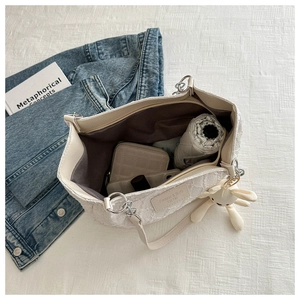 Détail intérieur du cabas en dentelle blanche avec parapluie et portefeuille matelassé