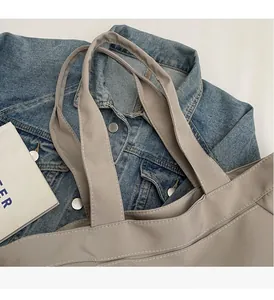 Close-up of reinforced handles and fine stitching on a durable fabric tote bag