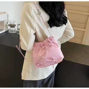 Petit sac seau plissé rose avec nœud décoratif et bandoulière en chaîne argentée