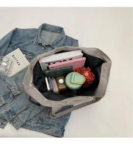 Internal view of large capacity nylon tote bag with books, tablet and umbrella