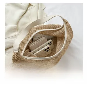 Large capacity straw hobo bag showing spacious interior with phones and a wallet