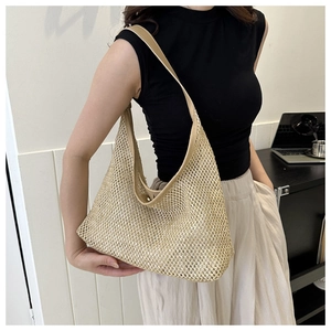 Detail of a beige woven straw hobo bag showing the hollow-out mesh texture and sturdy strap