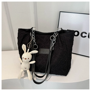 Détail du sac cabas plissé noir avec chaîne argentée et peluche lapin blanc