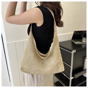 Detail of hand-woven beige mesh tote bag with wide shoulder strap in a lifestyle setting