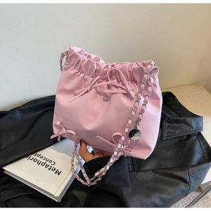 Petit sac seau rose à cordon avec nœuds décoratifs et bandoulière chaîne argentée