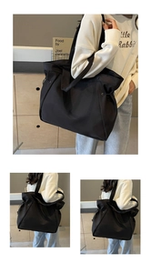 Vue détaillée du grand sac cabas en nylon noir avec cordon latéral et bandoulière fine