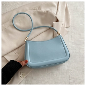 Detail of light blue minimalist baguette bag with matte leather and gold metal hardware