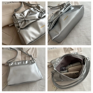 Detail view of silver PU leather tote with bow, ruched texture and interior storage